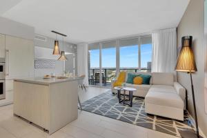 a kitchen and living room with a couch and a table at Bayview Luxury, 3BR Condo, Stunning Amenities in Hollywood