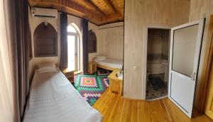 a small room with a bed and a bathroom at Khiva Siyovush Hotel in Khiva