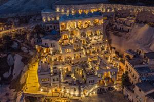 - une vue aérienne sur un grand bâtiment sur une falaise la nuit dans l'établissement Nino Cave Suites, à Ürgüp