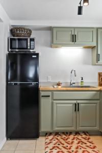 a kitchen with a black refrigerator and a sink at Boho Modern Retreat with Mountain Views Unit 1 Durango in Durango