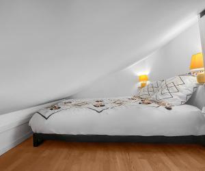 een witte slaapkamer met een bed met witte muren bij L'Écrin de Noiseau in Noiseau