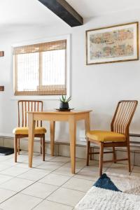 a dining room with a wooden table and two chairs at Boho Modern Retreat with Mountain Views Unit 1 Durango in Durango +3 photos