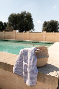 a towel on a basket next to a swimming pool at Casale degli Ulivi by Apulia Hospitality in Fasano