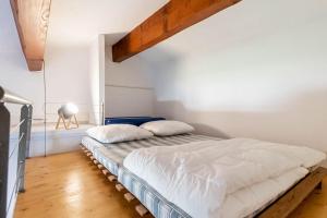 een bed in een witte kamer met een houten vloer bij La Terraza, T2 avec Clim, Parking, Port Marianne in Montpellier