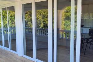 una puerta corredera de cristal en una casa con porche en 3 master bedrooms All-in-one, en Roseau