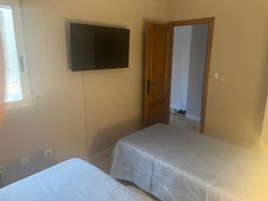 a bedroom with two beds and a flat screen tv at Parque De Las Naciones Europa II in Torrevieja +7 photos