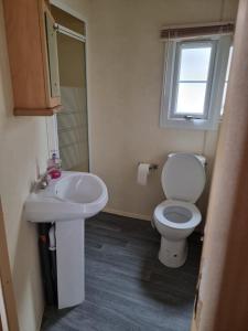 a bathroom with a toilet and a sink at promenade direct beach access in Ingoldmells