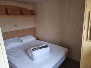 a bedroom with a white bed with two pillows at promenade direct beach access in Ingoldmells