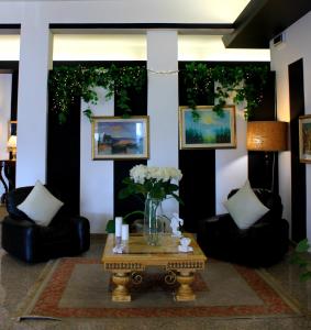un soggiorno con sedie e tavolo con fiori di Hotel Nuovo Sole HNS a Bovolone