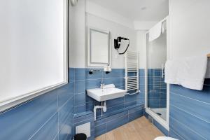 a blue bathroom with a sink and a mirror at Altona in Paris