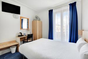 a hotel room with a bed and a desk and a window at Altona in Paris
