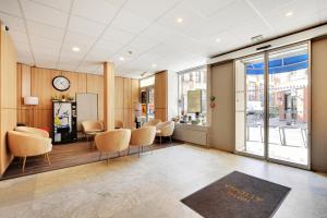 a room with chairs and a table and a clock at Altona in Paris