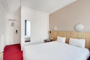 a bedroom with a large white bed and a window at Altona in Paris