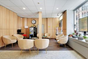 a waiting room with chairs and a clock on the wall at Altona in Paris