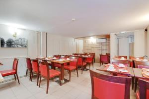 a restaurant with wooden tables and red chairs at Altona in Paris