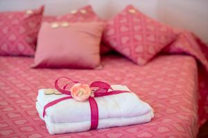 a towel with a rose on it sitting on a bed at Positano Casa Delizia in Positano