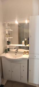 ein Bad mit einem Waschbecken und einem Spiegel in der Unterkunft Résidence les tonneliers in Mèze