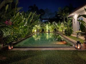 a swimming pool in the yard of a house at night at Roshe-Sky Guest House Colombo in Mahabage