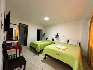 a hotel room with two beds and a television at Hotel Ñuñurco Travellers in Chachapoyas
