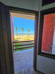 a door to a room with a view of the beach at Pousada Varanda da Praia in Conceição da Barra