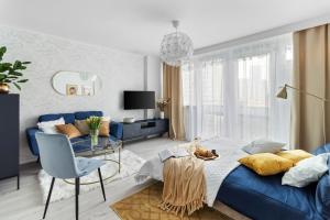 a living room with a blue couch and a glass table at Beautiful freshly renovated studio in Warsaw centre, full comfort metro Smart TV parking in Warsaw