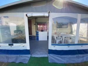 una vista esterna di una tenda con un tavolo all'interno di Camping Mayer a Cavallino-Treporti