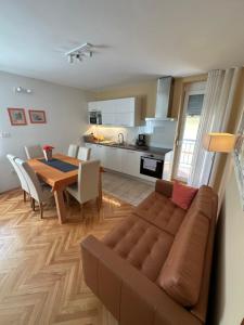 ein Wohnzimmer und eine Küche mit einem Sofa und einem Tisch in der Unterkunft Apartment with balcony Hiša Brdo 48 in Bovec