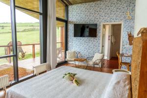 een slaapkamer met een bed en een groot raam bij Suites Niditas in Yuso