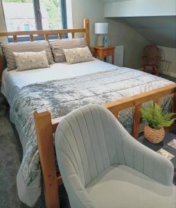 een slaapkamer met een groot bed en een stoel bij Englefield Guesthouse in Goathland