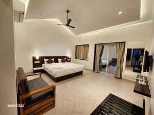 a large bedroom with a bed and a balcony at Basil Leaf Resort in Alibag