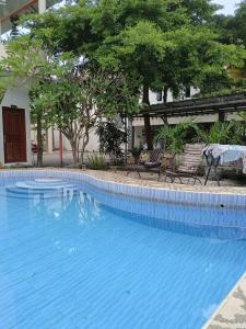 a large blue swimming pool with chairs and trees at Solo Nadamax City Guest House Syariah in Bonorejo