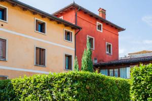 un gran edificio rojo con arbustos delante de él en Una piccionaia contemporanea en Vicenza