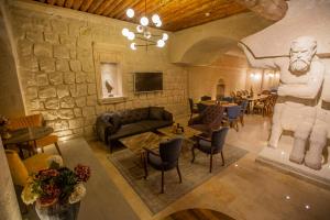 a living room with a statue and tables and chairs at Nino Cave Suites in Urgup