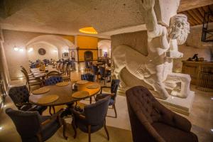 un restaurant avec des tables et des chaises et un lion sur le mur dans l'établissement Nino Cave Suites, à Ürgüp