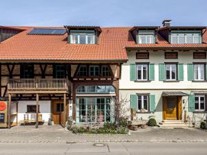 ein großes Haus mit orangefarbenem Dach in der Unterkunft Obst- Ferienhof Ragg in Immenstaad am Bodensee