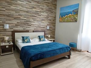 a bedroom with a bed and a brick wall at Domos La Corte Ghibellina in Iglesias