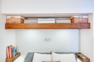 estante de madera sobre una cama con almohadas en North Wildwood Condo with Shared Pool, Walk to Beach, en North Wildwood