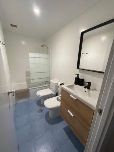 ein Badezimmer mit einem weißen WC und einem Waschbecken in der Unterkunft Apartamento Cueto II in Soto del Barco