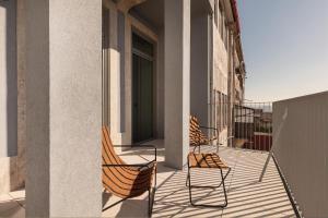 2 sillas sentadas en el balcón de un edificio en Vandoma, en Oporto