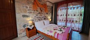 a bedroom with a bed and a stone wall at Stoupa's Paradise in Stoupa