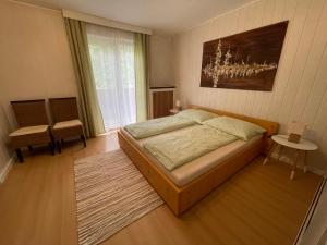 a bedroom with a bed and a large window at Haus Landruhe in Greifenburg