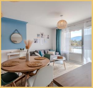 uma sala de estar com uma mesa e cadeiras e um sofá em Appart T2 Elegant St Julien em Saint-Julien-en-Genevois