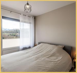 a bedroom with a bed and a window at Appart T2 Elegant St Julien in Saint-Julien-en-Genevois