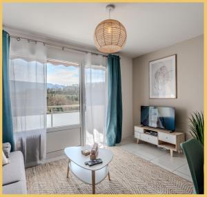 ein Wohnzimmer mit einem großen Fenster und einem TV in der Unterkunft Appart T2 Elegant St Julien in Saint-Julien-en-Genevois