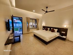 a bedroom with a bed and a television in it at Basil Leaf Resort in Alibag