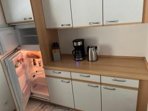 a kitchen with an open refrigerator with a coffee maker at Privatzimmer nähe Residenz und Innenstadt in Würzburg
