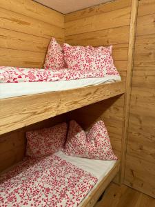 2 łóżka piętrowe z białymi i czerwonymi poduszkami w pokoju w obiekcie TOP 40 w mieście Warth am Arlberg