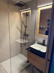 W łazience znajduje się szklana kabina prysznicowa i umywalka. w obiekcie TOP 40 w mieście Warth am Arlberg