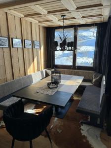 stół i krzesła w pokoju z dużym oknem w obiekcie TOP 40 w mieście Warth am Arlberg