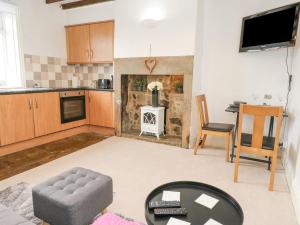 a kitchen with a living room with a fireplace at Luna Cottage in Holmfirth